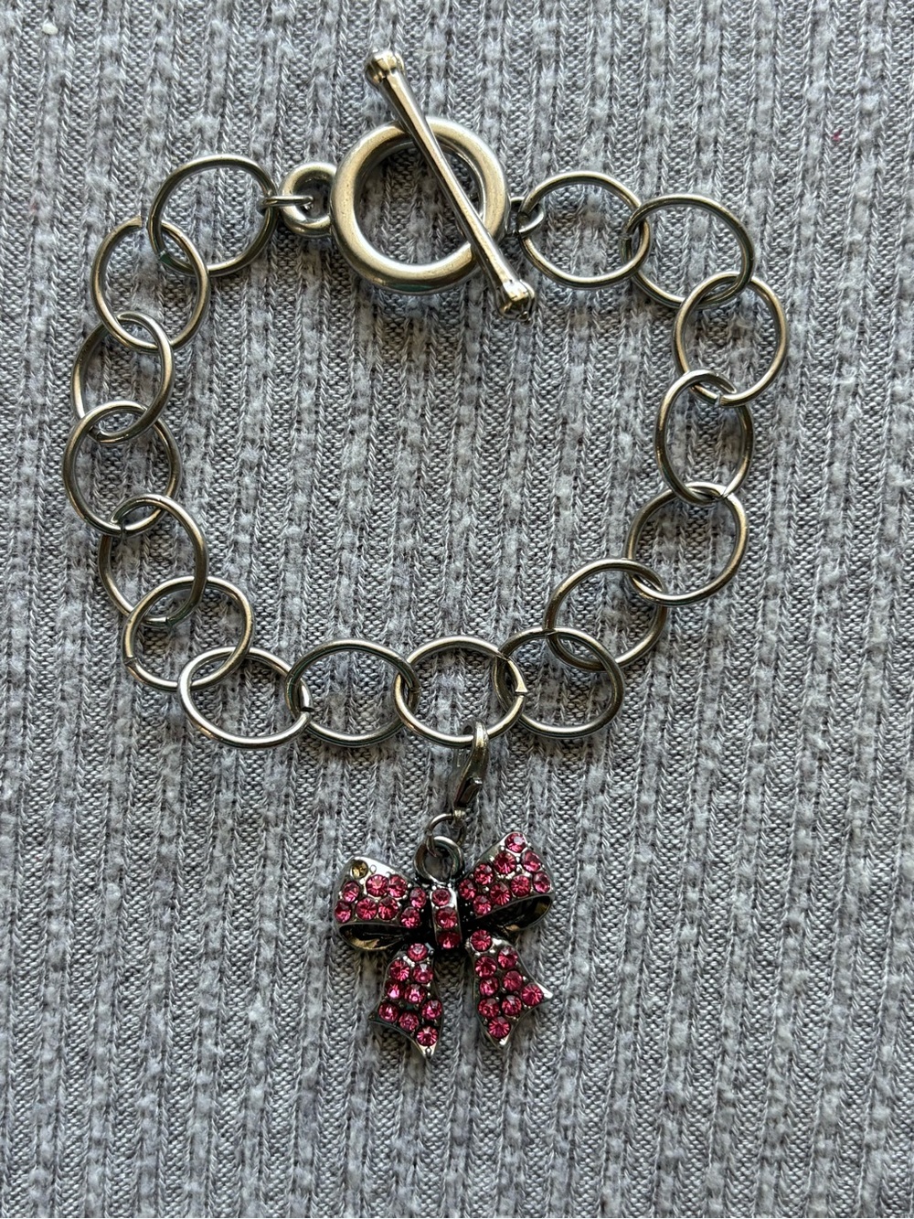 Vintage silver tone bracelet w dangly pink rhinestone bow charm-1 stone missing